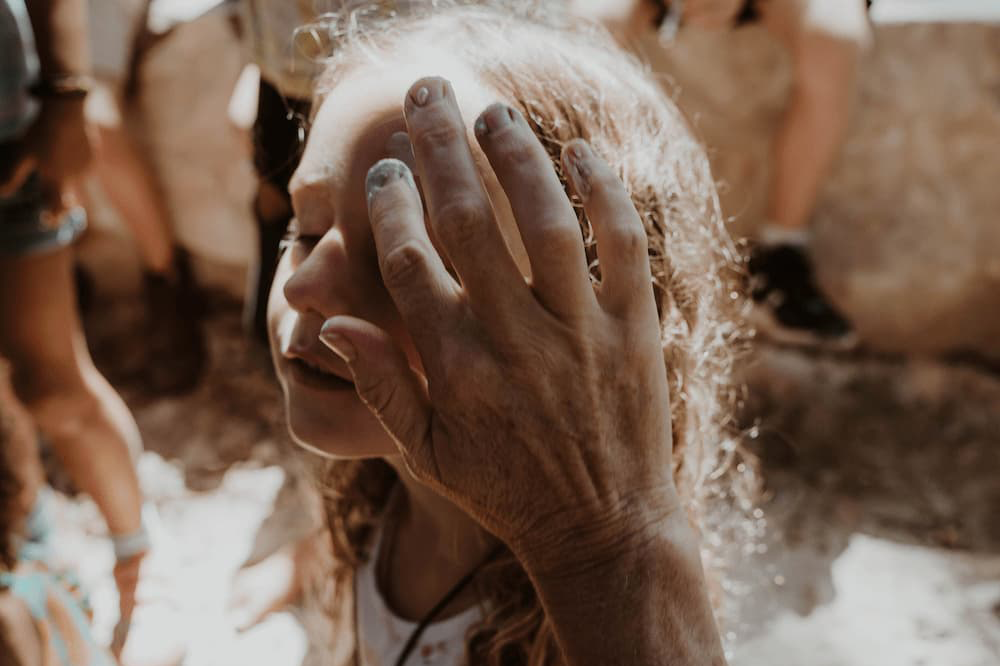 Young girl with her eyes closed has ochre applied to her face